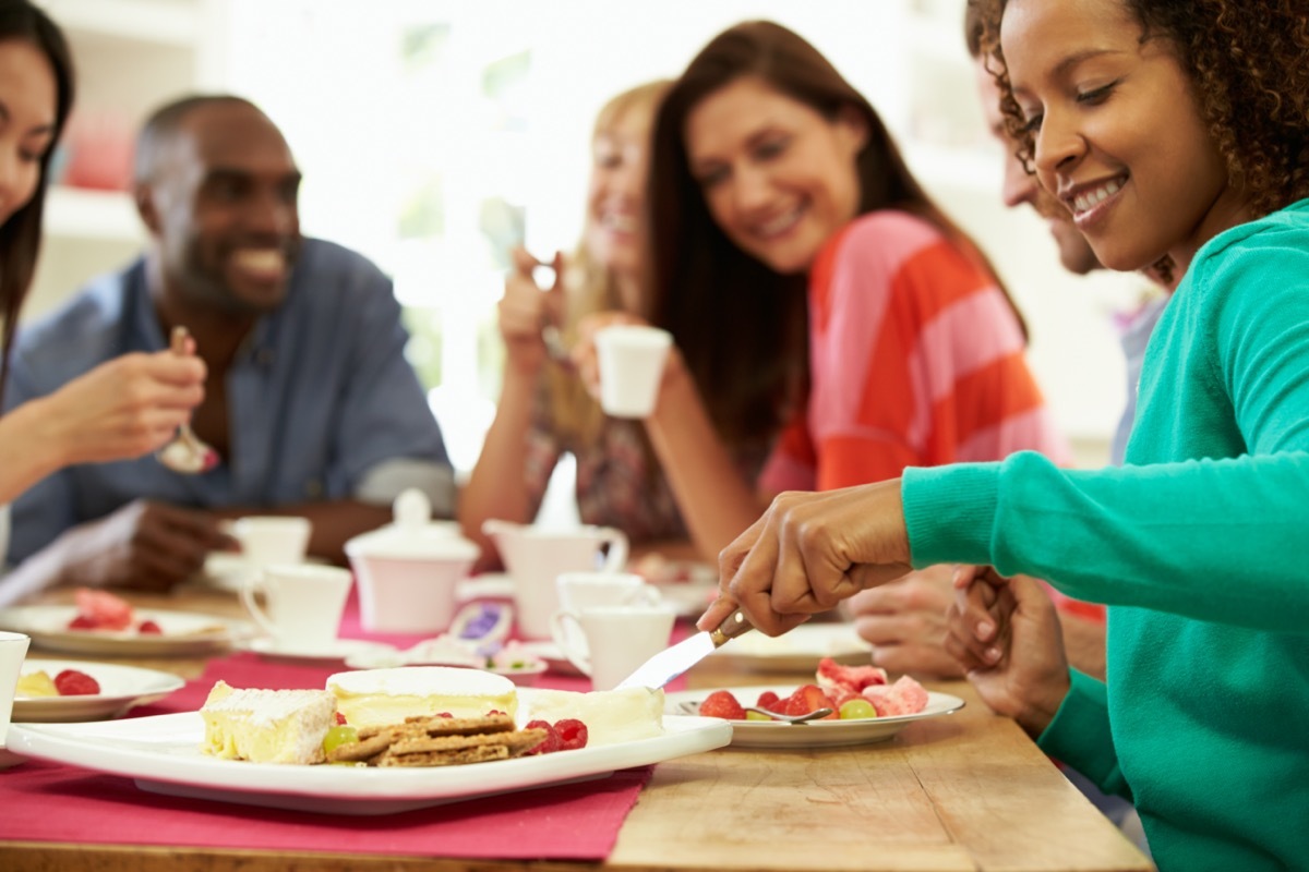 Group Of Friends Sitting Around Table Having Dinner Party