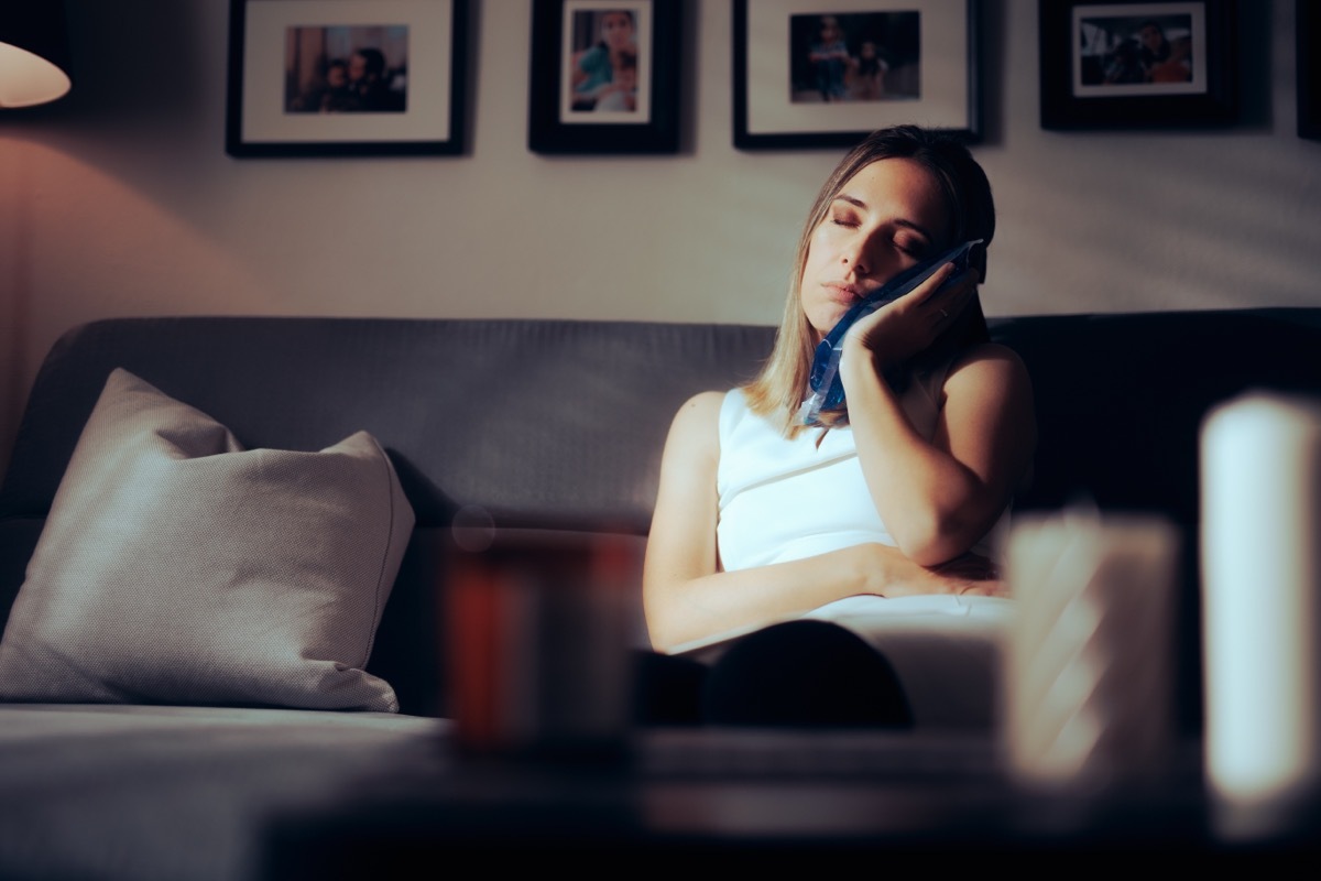 Woman holding cold compress to cheek