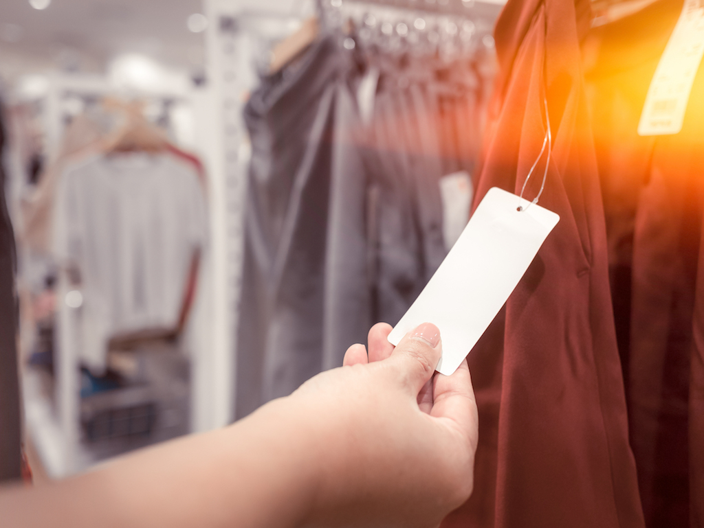 woman looking at a price tag shopping