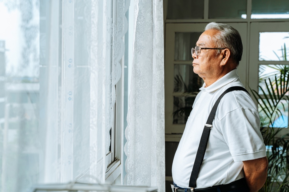 serious old man looking out his window