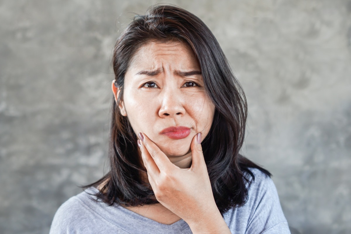 woman having problem with Bell's Palsy/Facial Palsy, hand holding her face