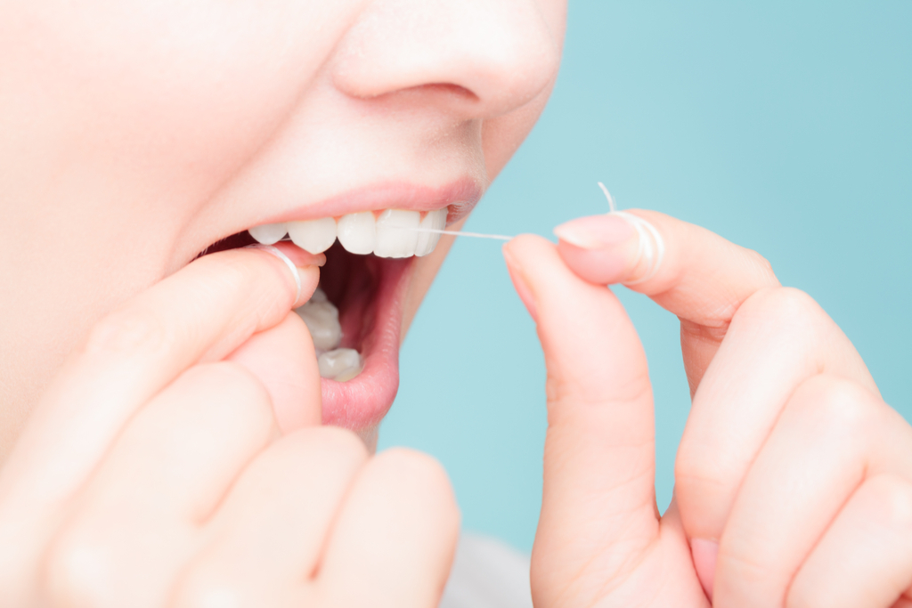 Woman Flossing Teeth