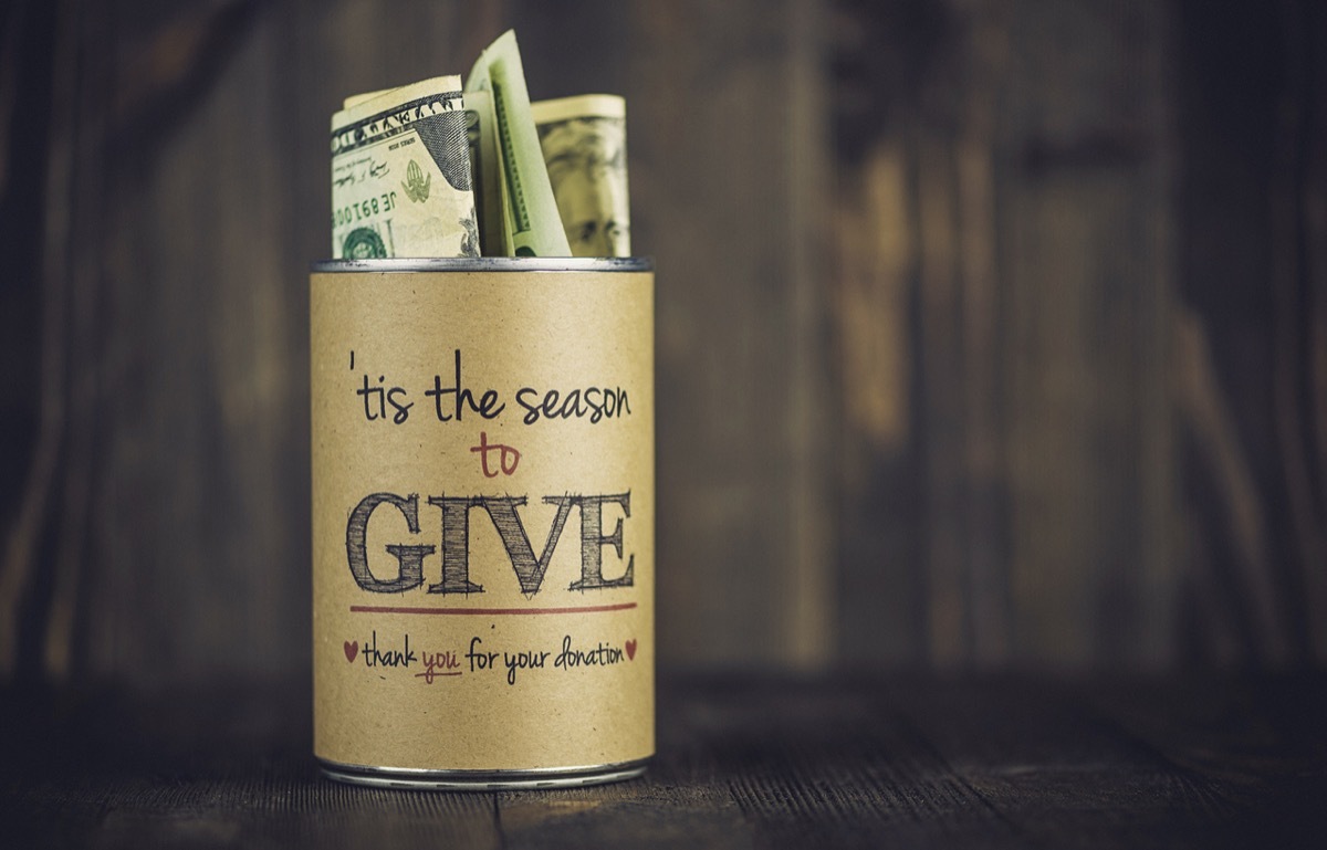 Charity collecting tin against wooden background. American holiday fundraising