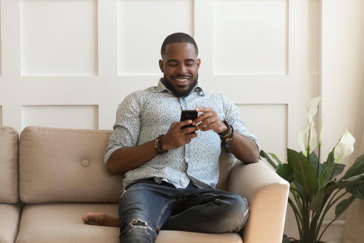 Young Black man smiling at phone