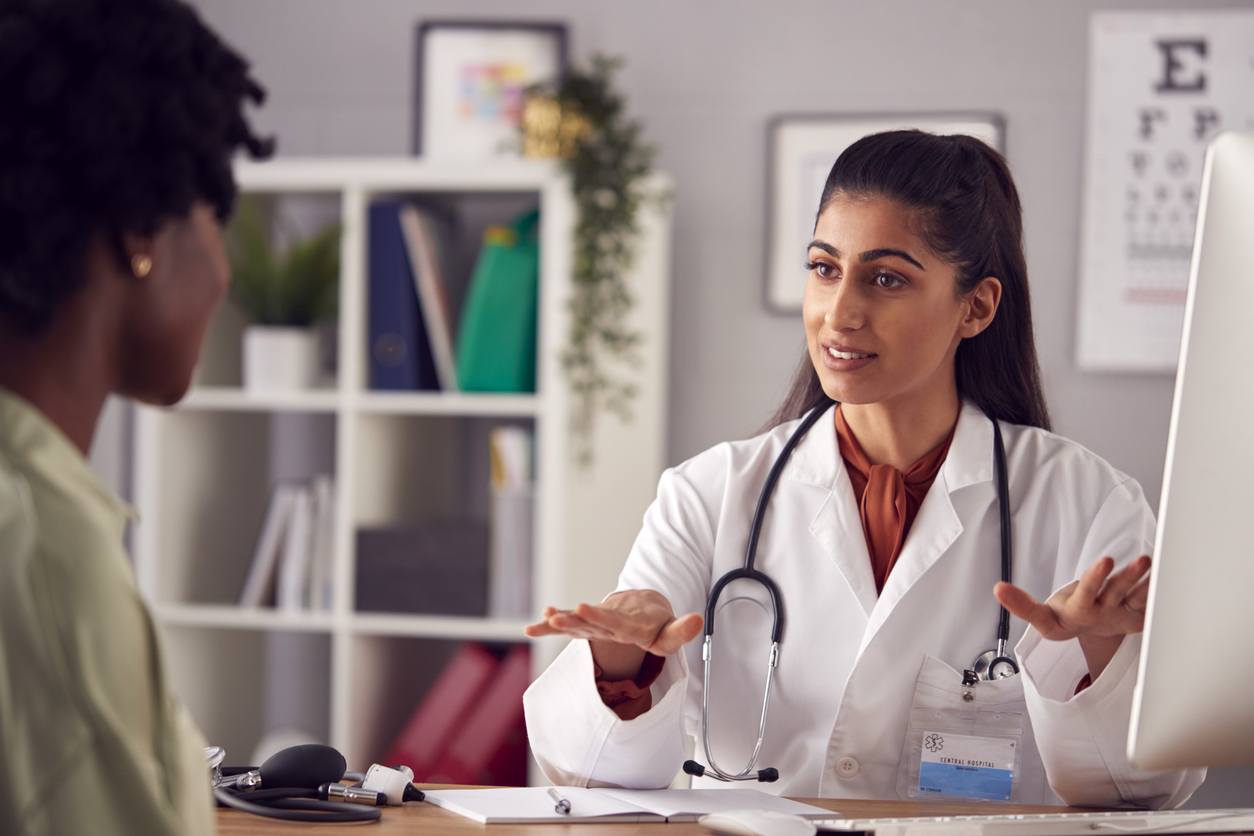 Doctor speaking with patient in an office.