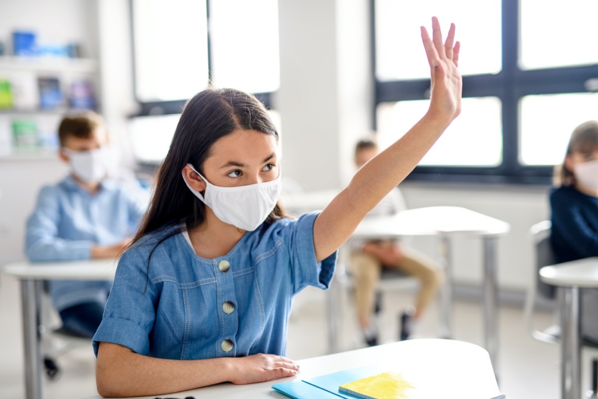 Girl with face mask back at school after covid-19 quarantine and lockdown.