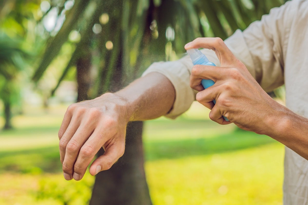 man using bug spray