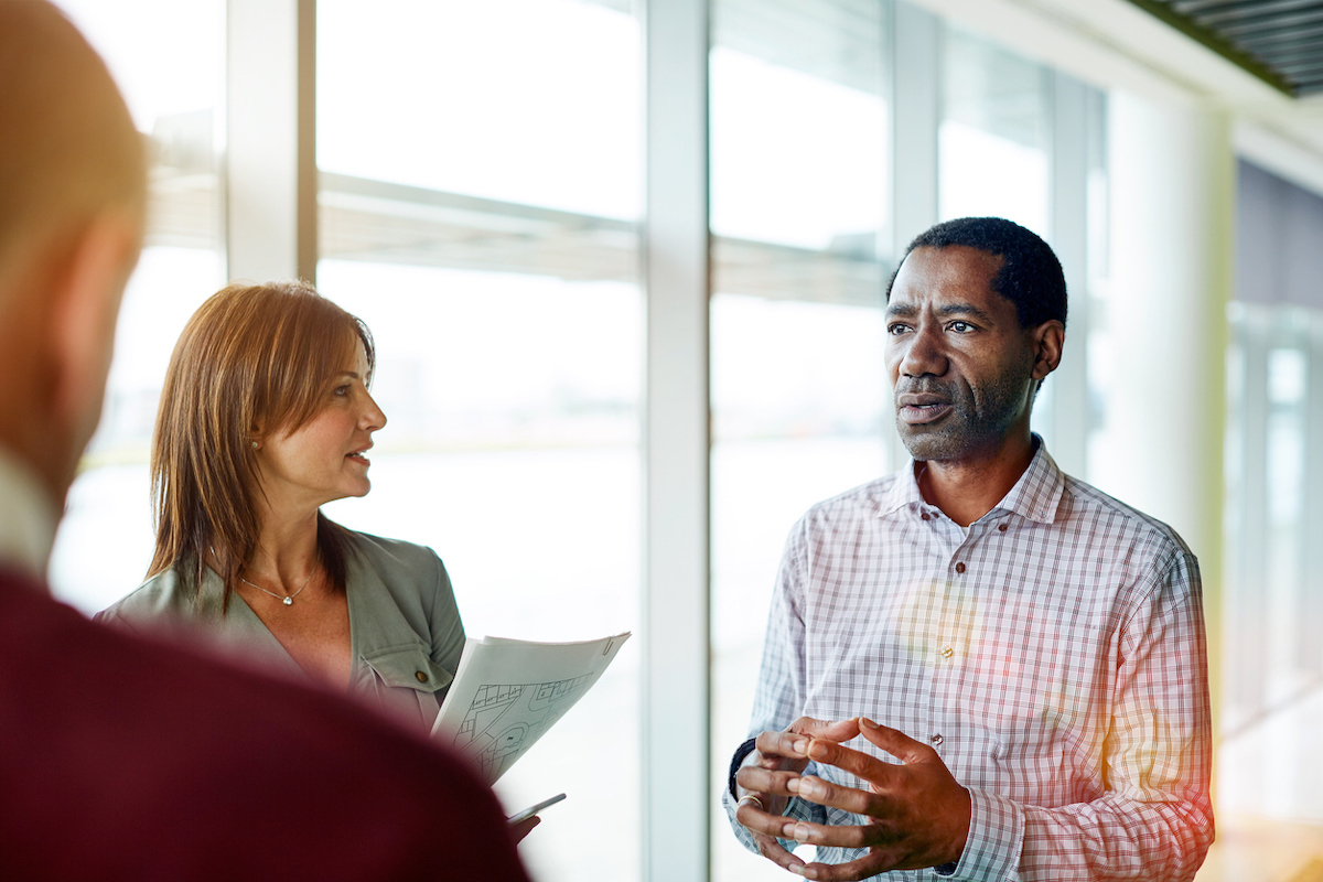 Group of business colleagues talking while standing in their office