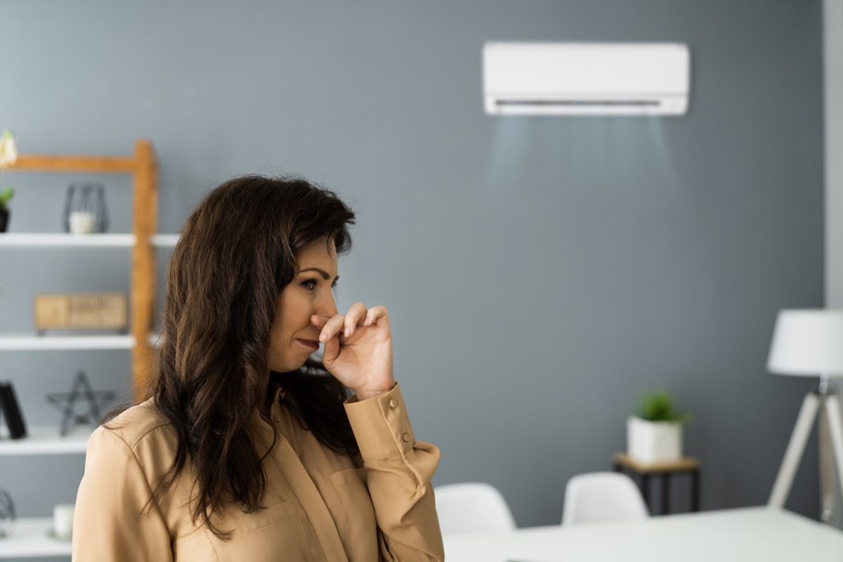 Woman smells something in home