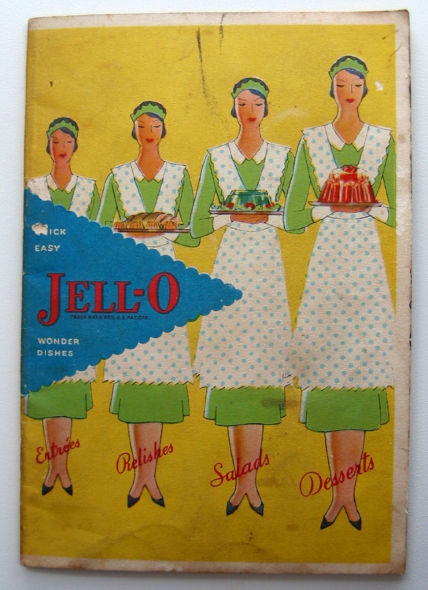 The front cover has a yellow background and a blue triangle behind the title. There are four maids dressed in green with green polka dot aprons, carrying a variety of Jell-O molds.