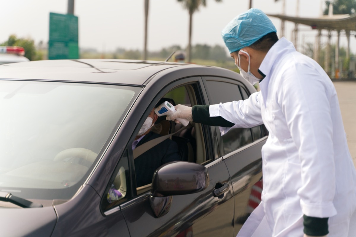 The doctors checking temperature at the temperature check post on the highway exit.