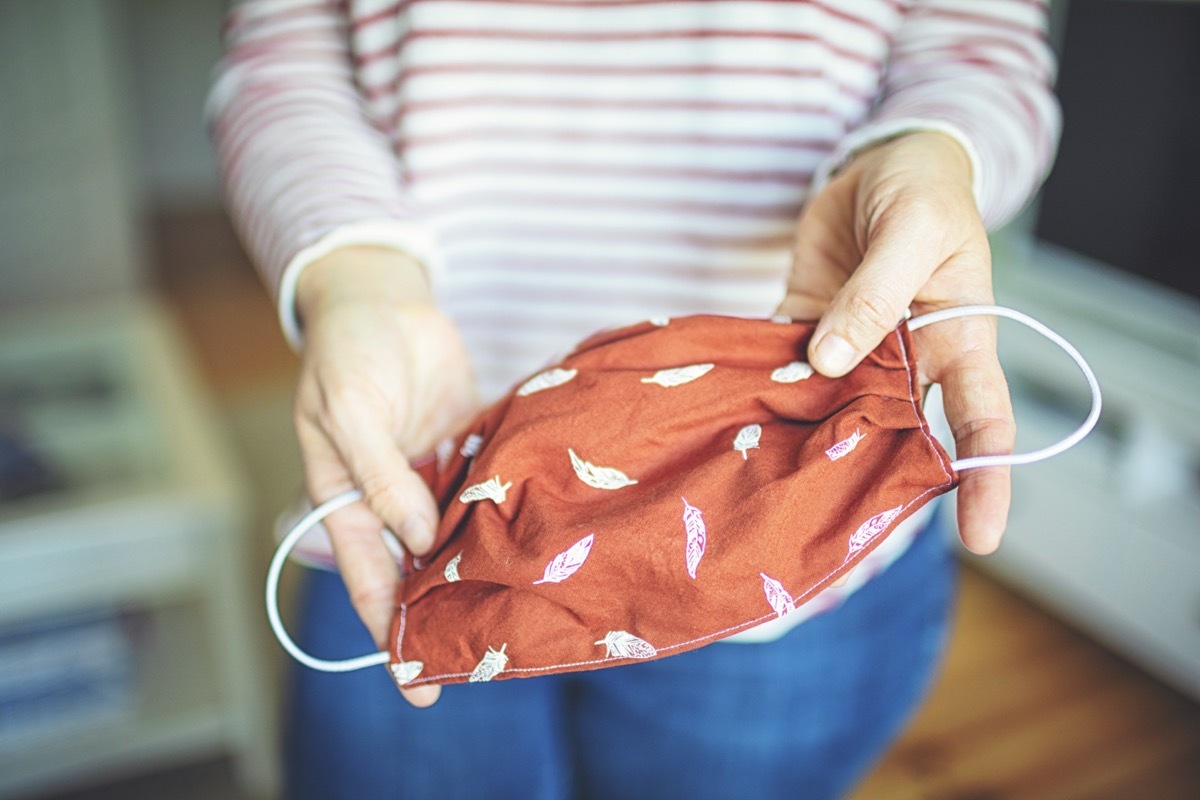 Young woman shows self-made face mask.