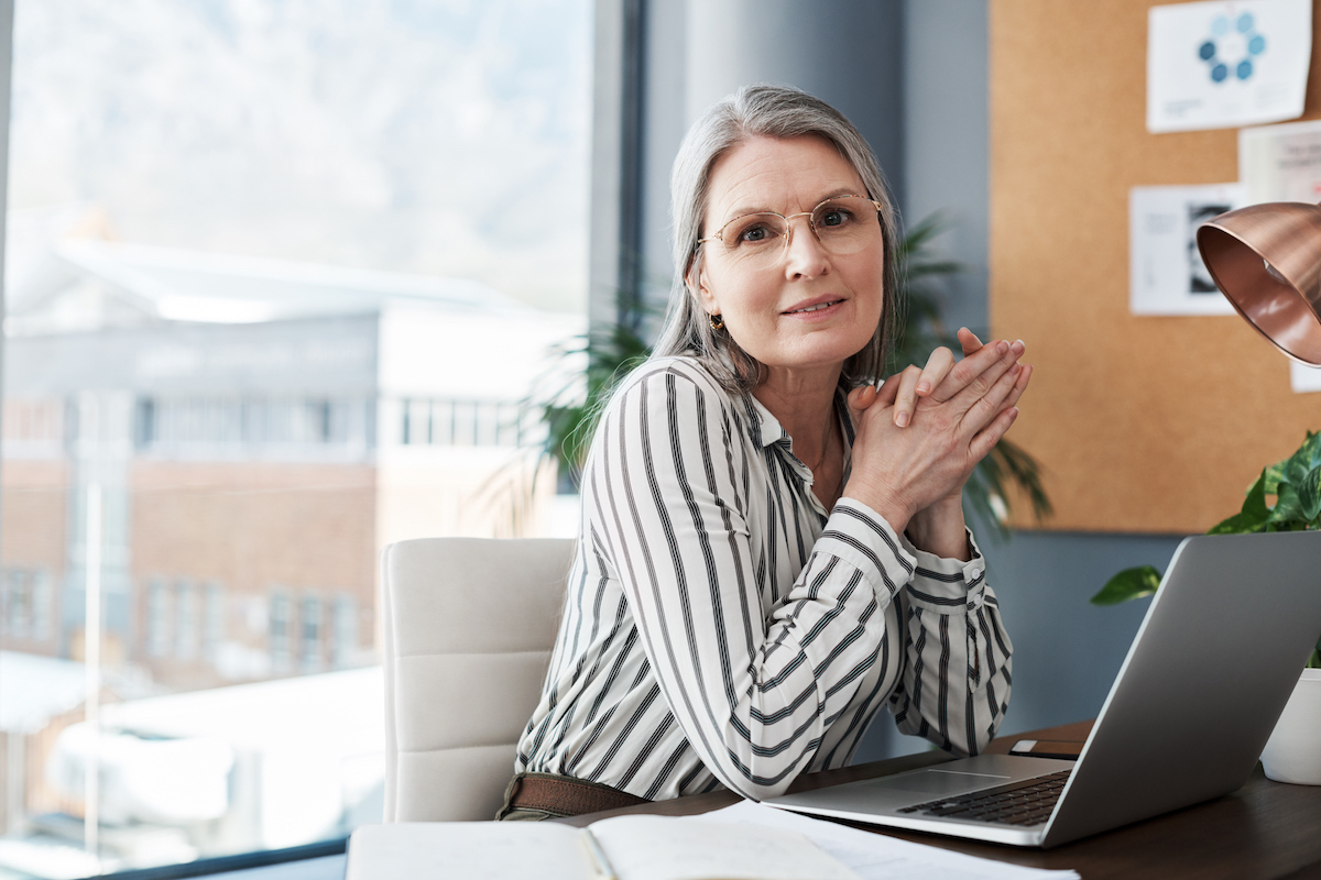 Portrait of a proud businesswoman with gray hair in a modern office